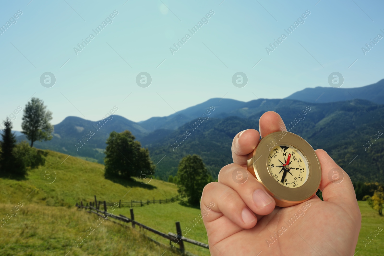 Image of Man using compass in mountains, closeup. Navigational instrument