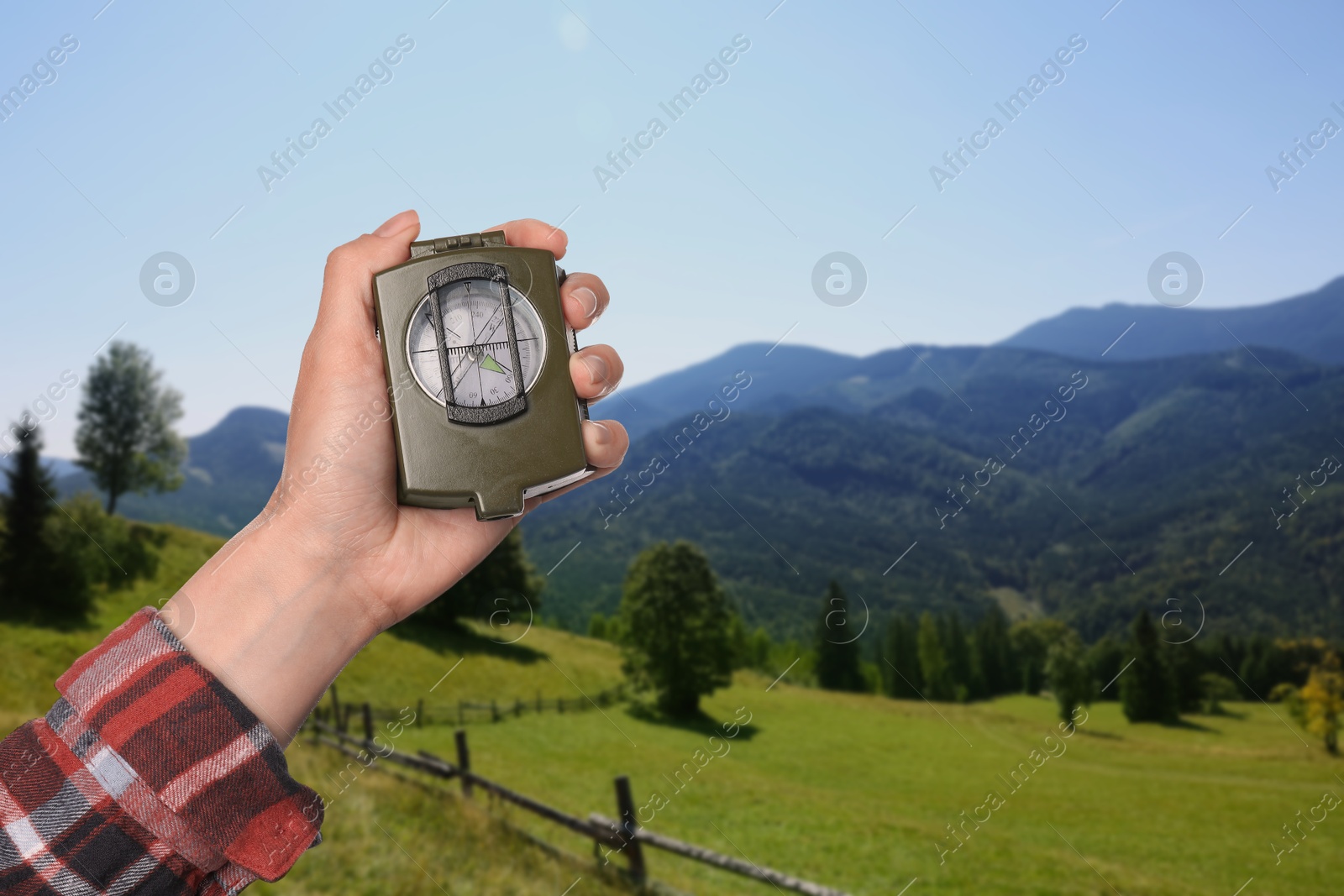 Image of Woman using compass in mountains, closeup. Navigational instrument