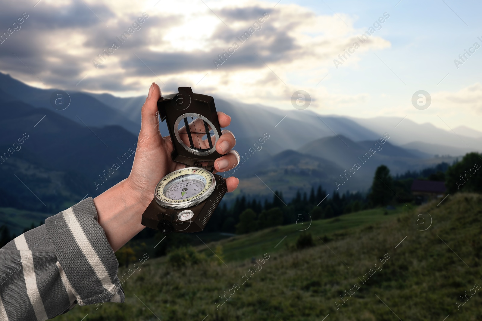 Image of Woman using compass in mountains, closeup. Navigational instrument