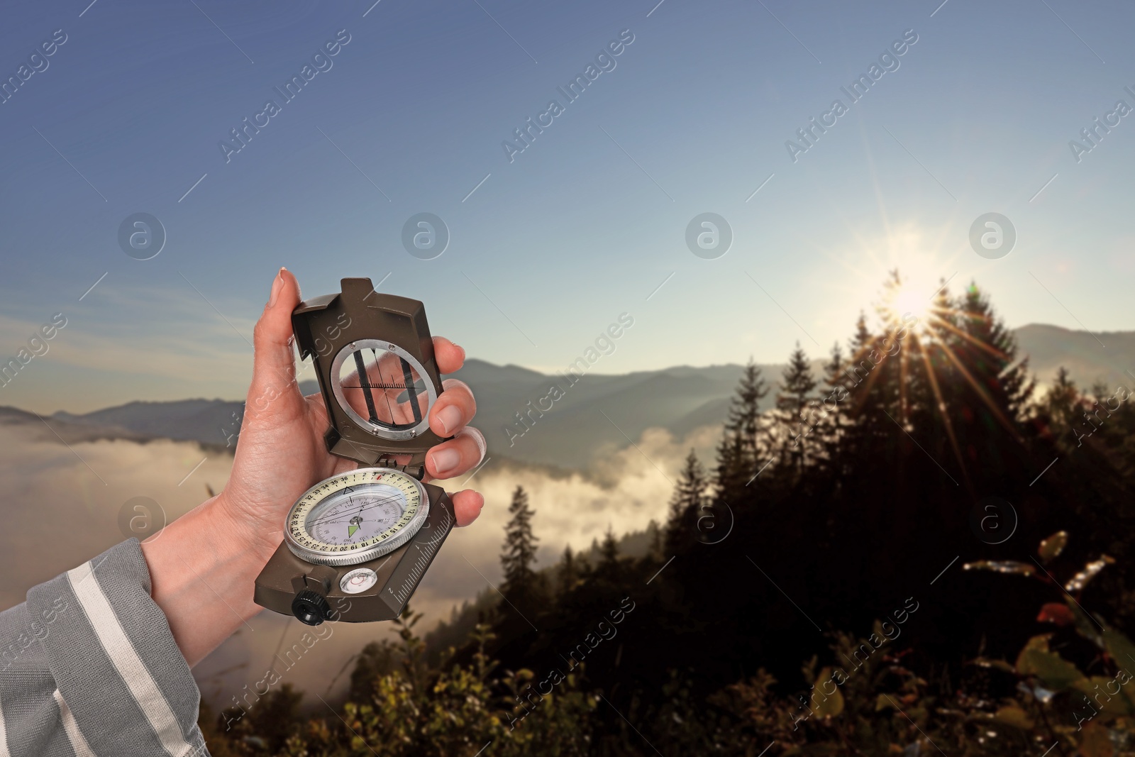 Image of Woman using compass in mountains, closeup. Navigational instrument