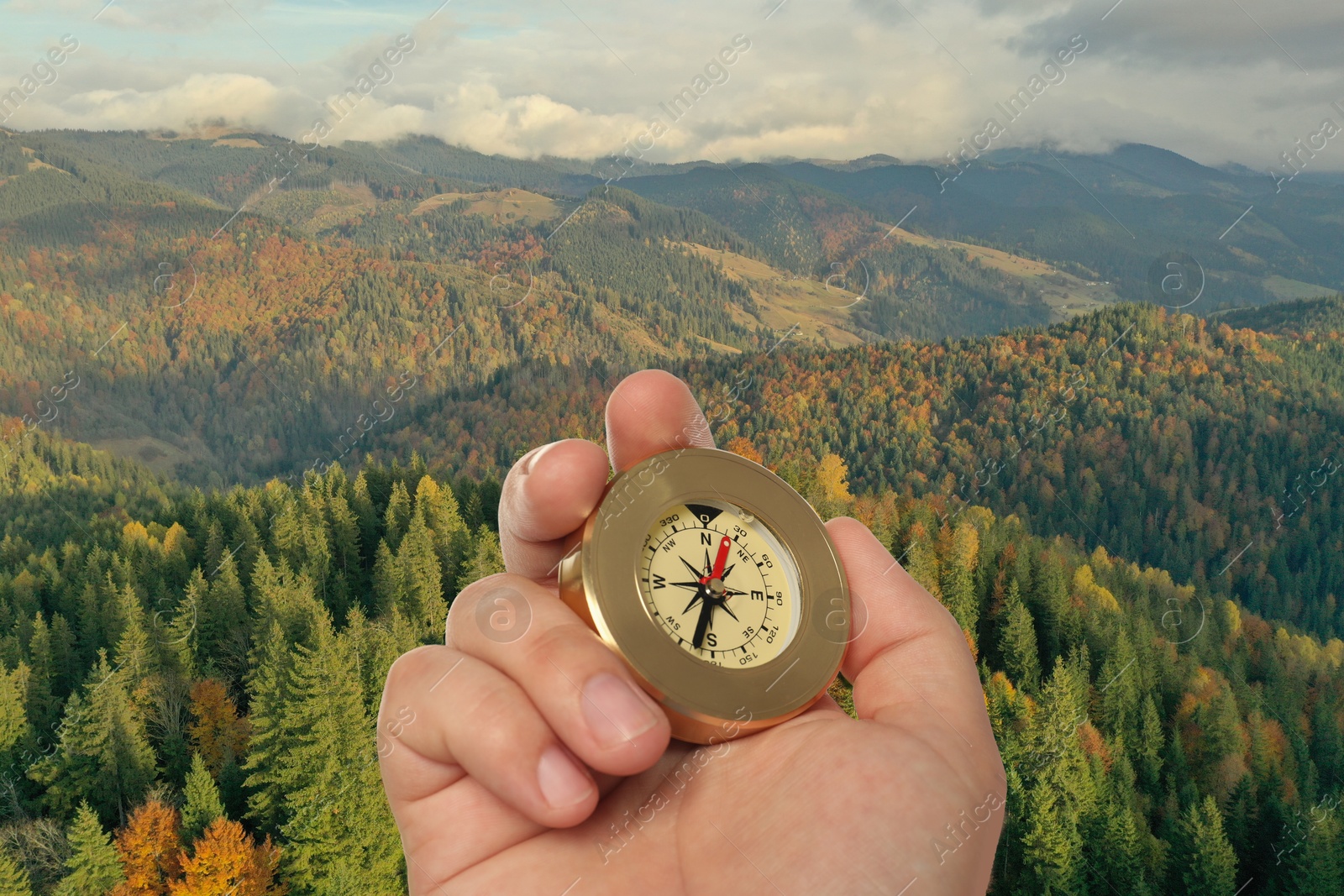 Image of Man using compass in mountains, closeup. Navigational instrument