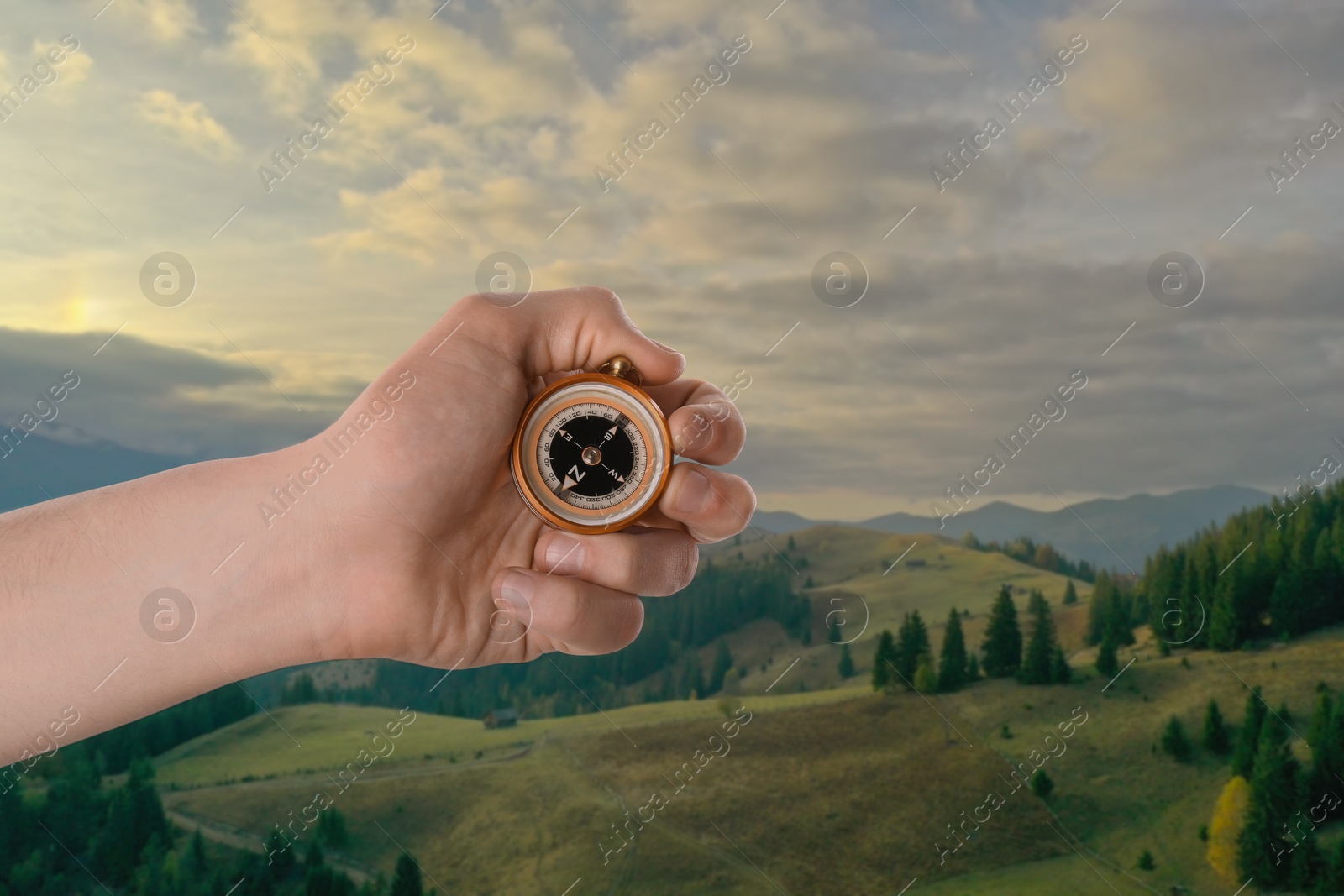 Image of Man using compass in mountains, closeup. Navigational instrument