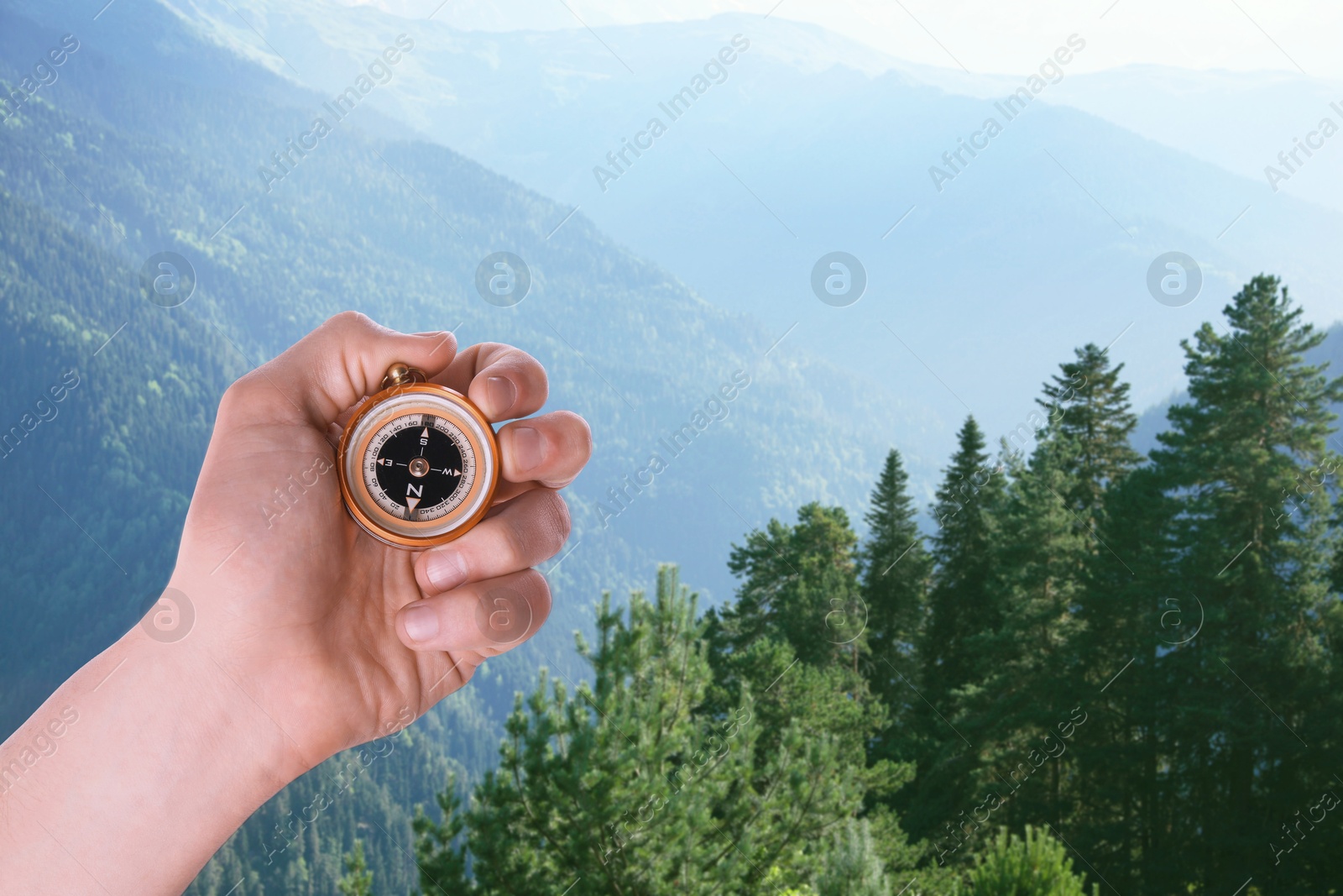 Image of Man using compass in mountains, closeup. Navigational instrument