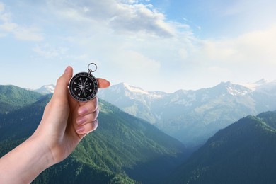 Image of Woman using compass in mountains, closeup. Navigational instrument