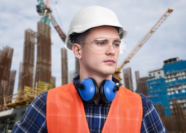 Image of Young man wearing safety equipment at construction site