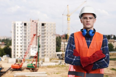 Image of Young man wearing safety equipment at construction site. Space for text