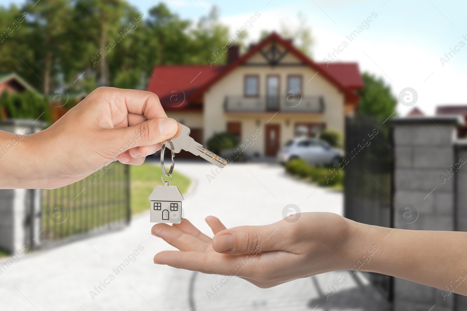 Image of Real estate agent giving house key to new owner against beautiful dwelling, closeup