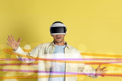 Image of Man using virtual reality headset on yellow background. Modern technology. Bright lines around him