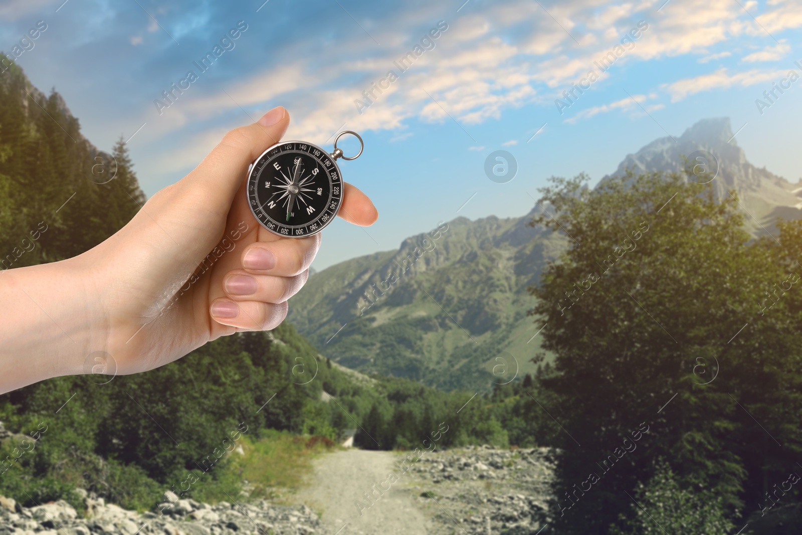 Image of Woman using compass in mountains, closeup. Navigational instrument