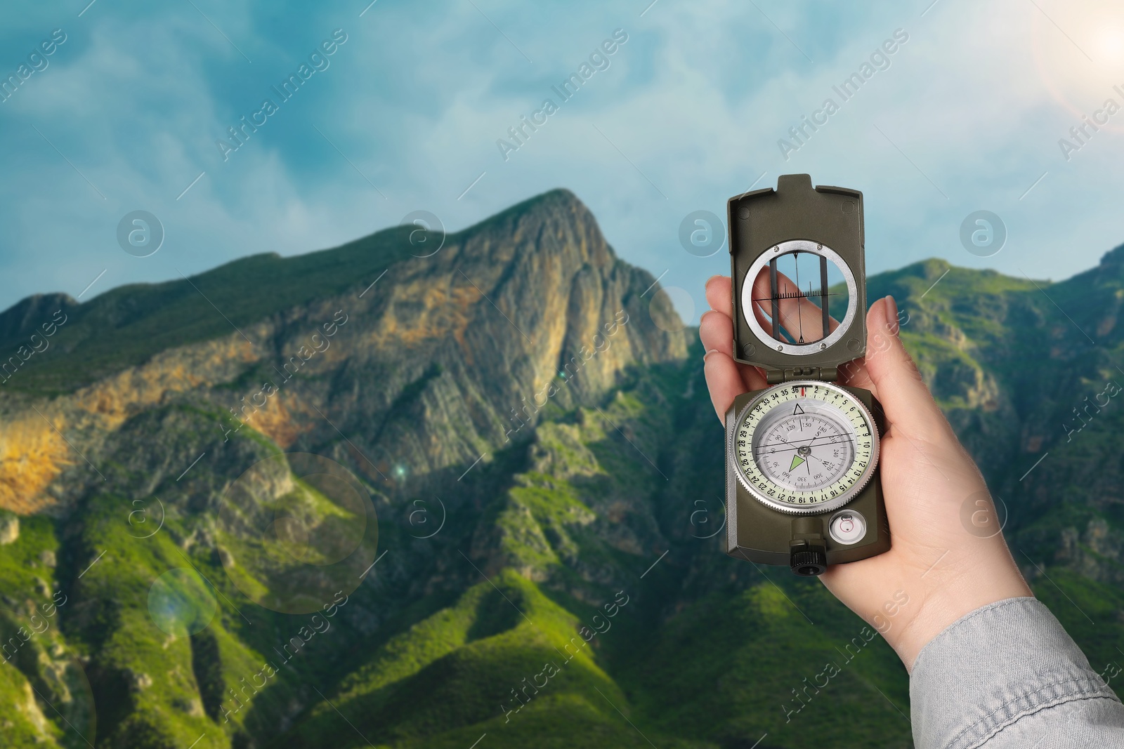 Image of Woman using compass in mountains, closeup. Navigational instrument