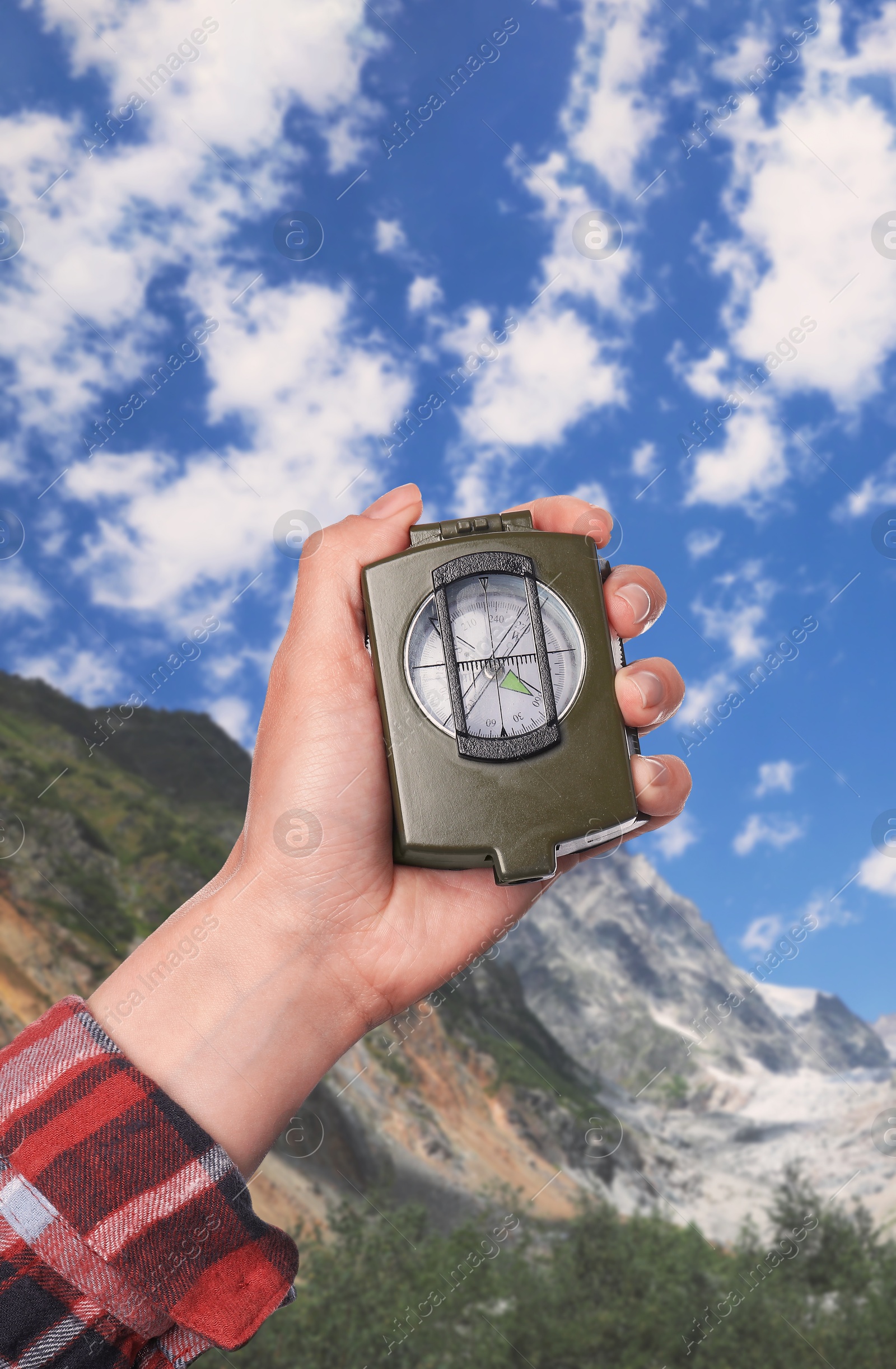 Image of Woman using compass in mountains, closeup. Navigational instrument