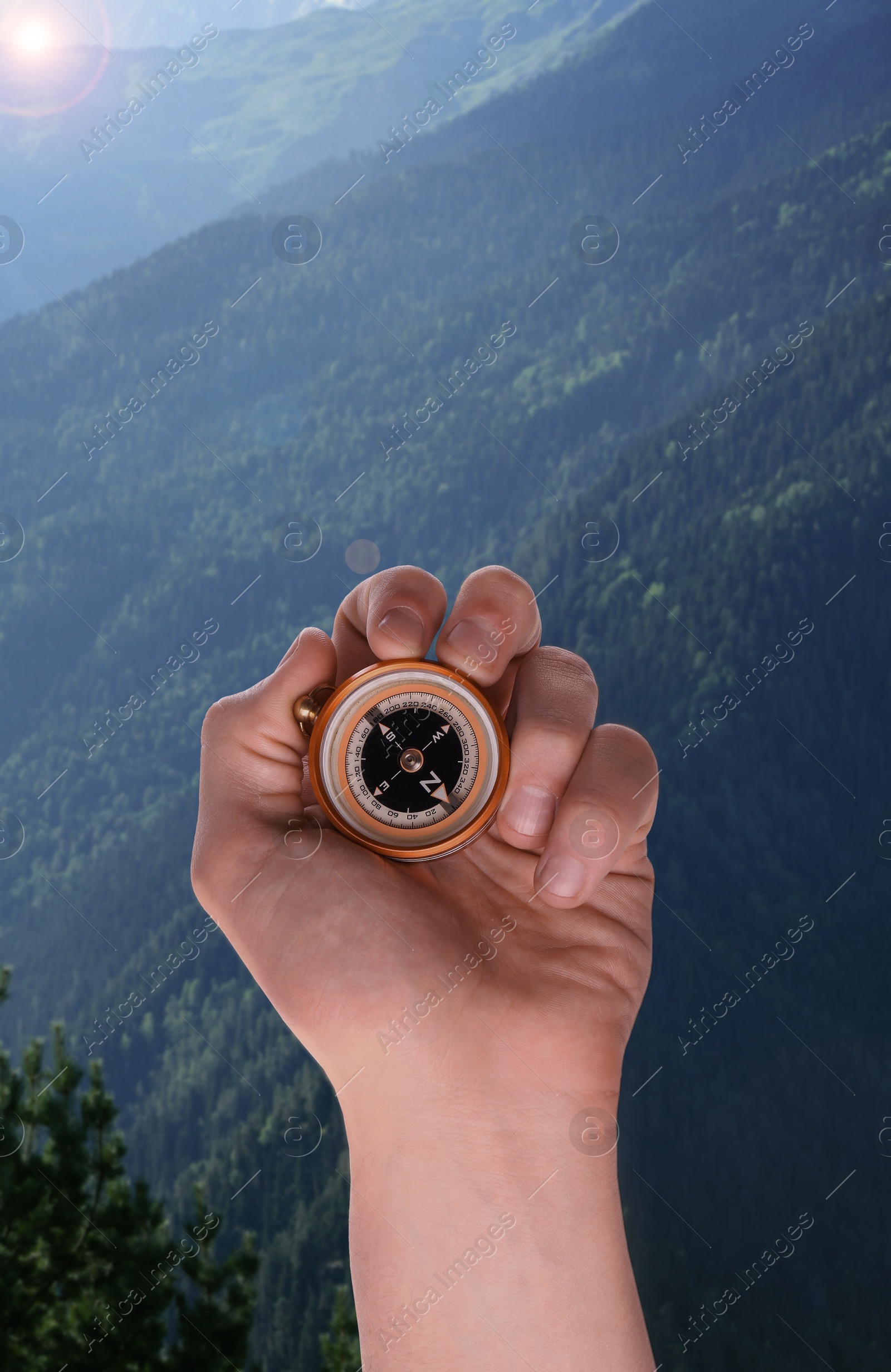 Image of Man using compass in mountains, closeup. Navigational instrument