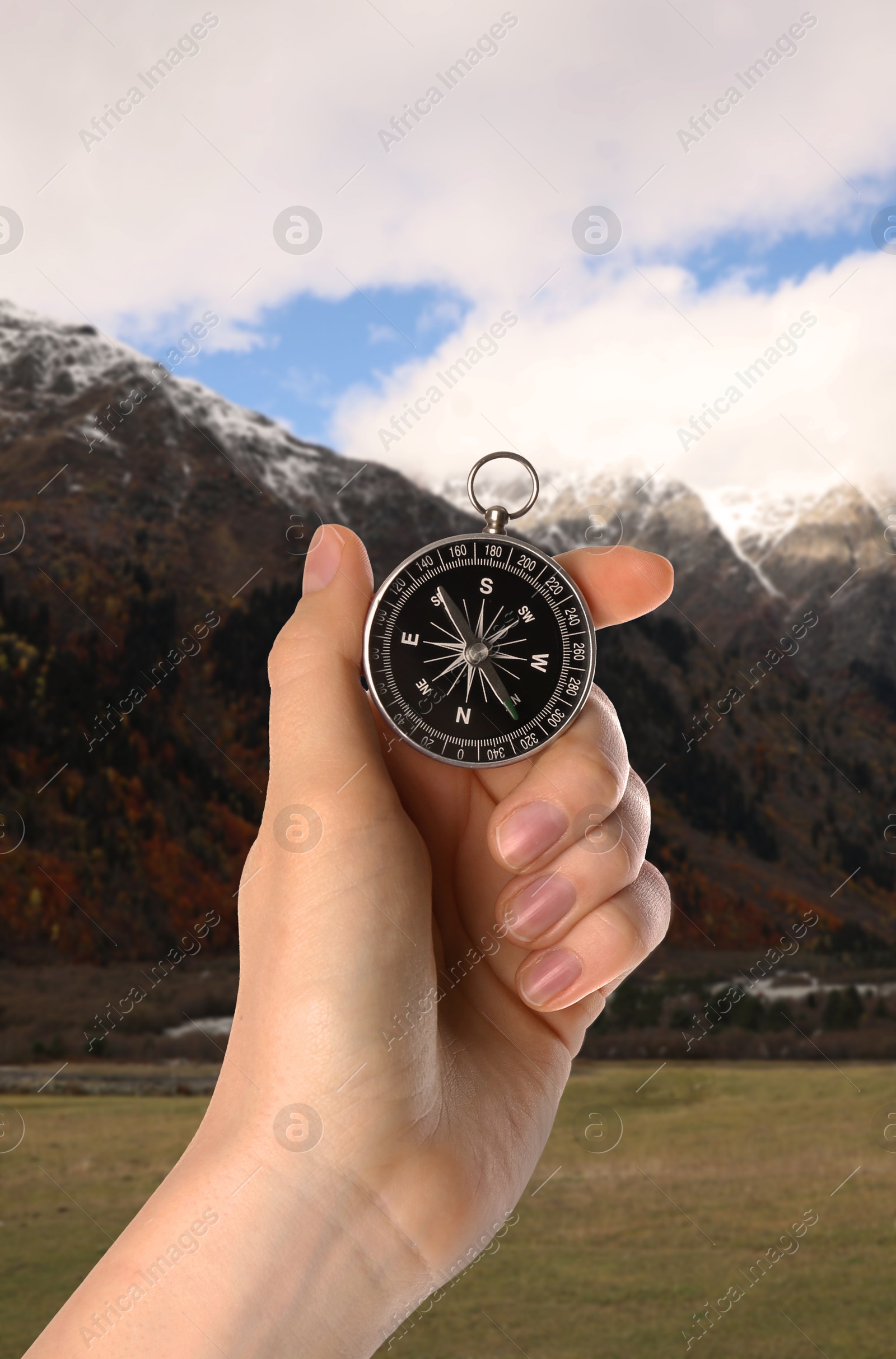 Image of Woman using compass in mountains, closeup. Navigational instrument