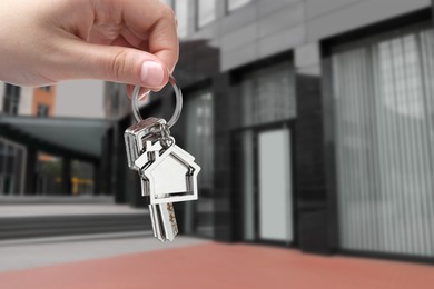 Image of Real estate agent holding keys against future dwelling, closeup