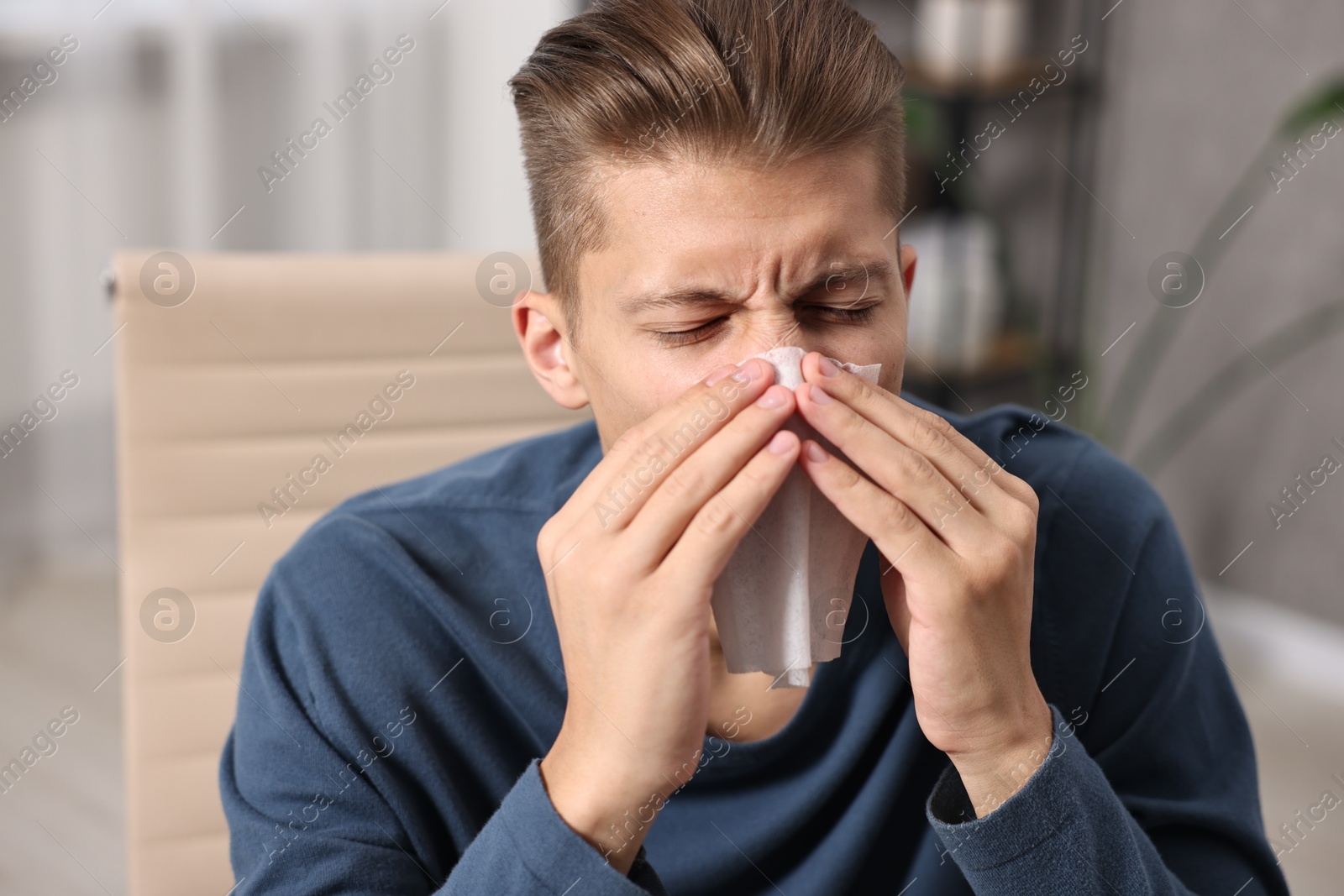 Photo of Young man with tissue suffering from sinusitis indoors