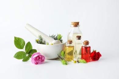 Photo of Aromatherapy. Different essential oils, flowers, mortar, pestle and fir twigs on white background