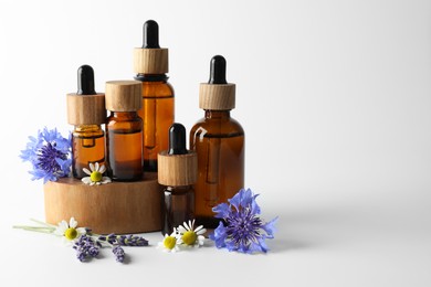 Photo of Aromatherapy. Different essential oils and flowers on white background, space for text