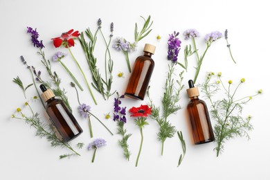 Photo of Aromatherapy. Essential oils, flowers and rosemary on white background, flat lay