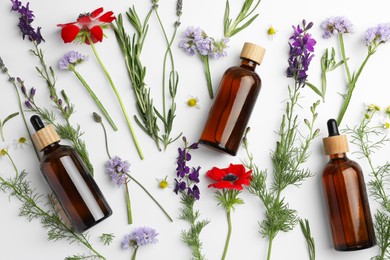 Aromatherapy. Essential oils, flowers and rosemary on white background, flat lay