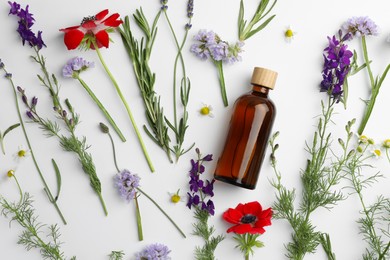 Photo of Aromatherapy. Essential oil, flowers and rosemary on white background, flat lay