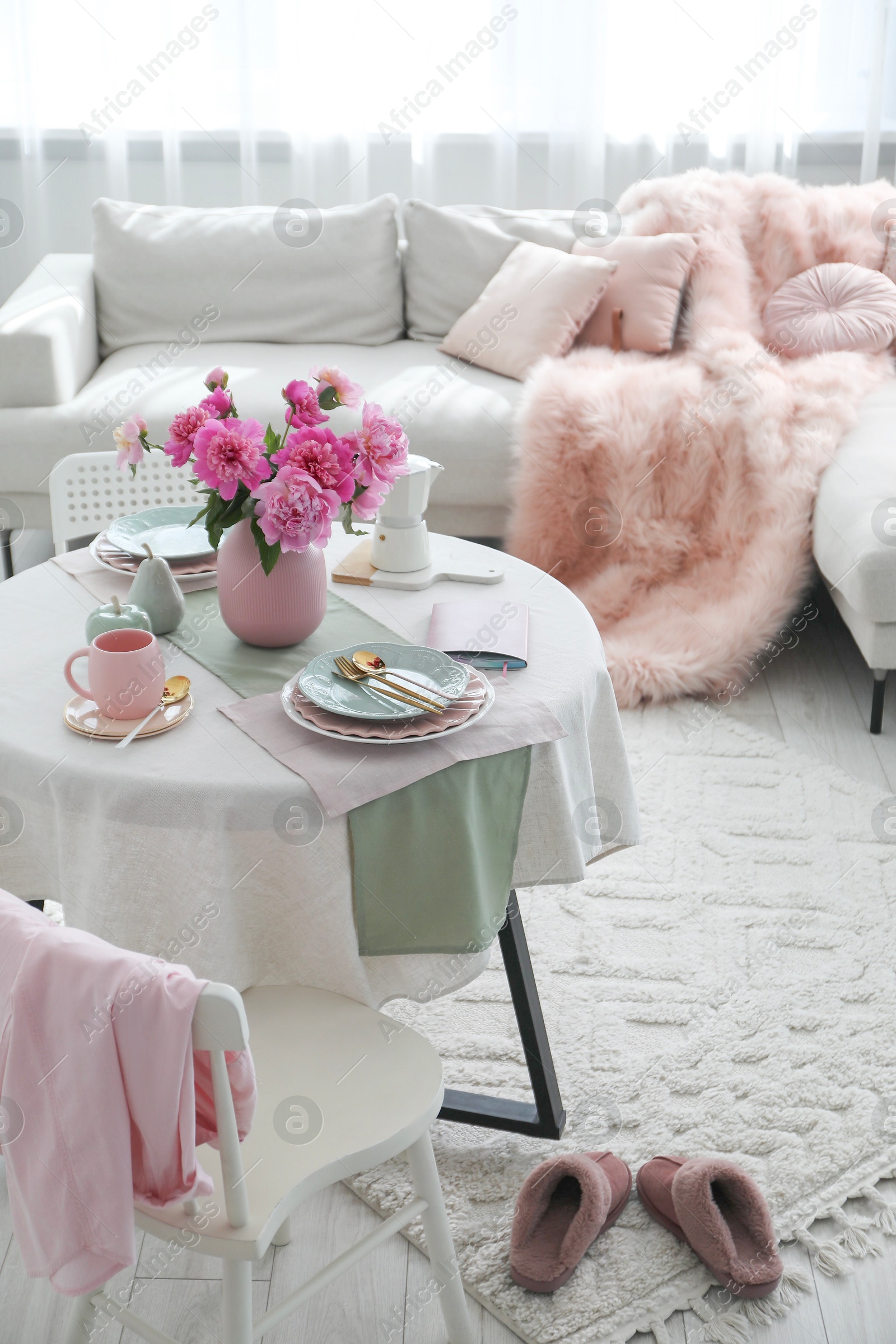 Photo of Beautiful table setting with pink peonies in living room