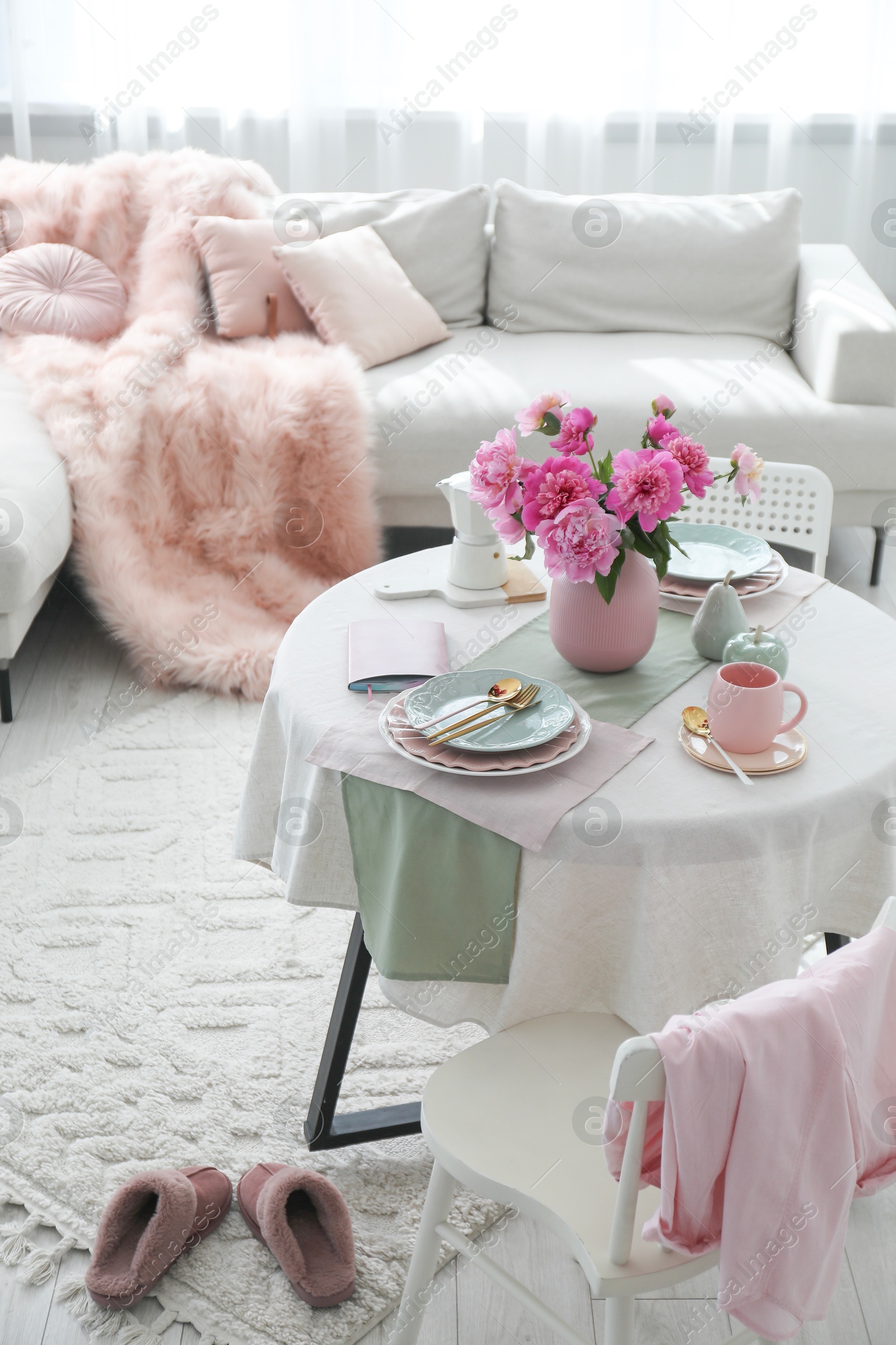 Photo of Beautiful table setting with pink peonies in living room