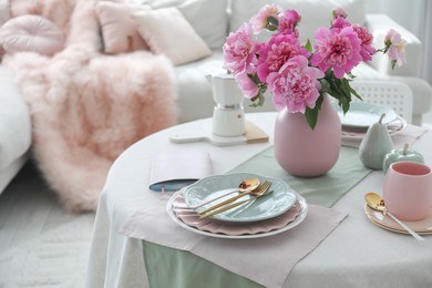 Photo of Beautiful table setting with pink peonies in dining room