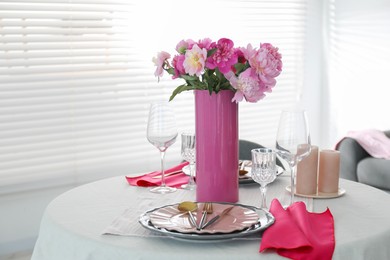 Beautiful table setting with pink peonies and candles