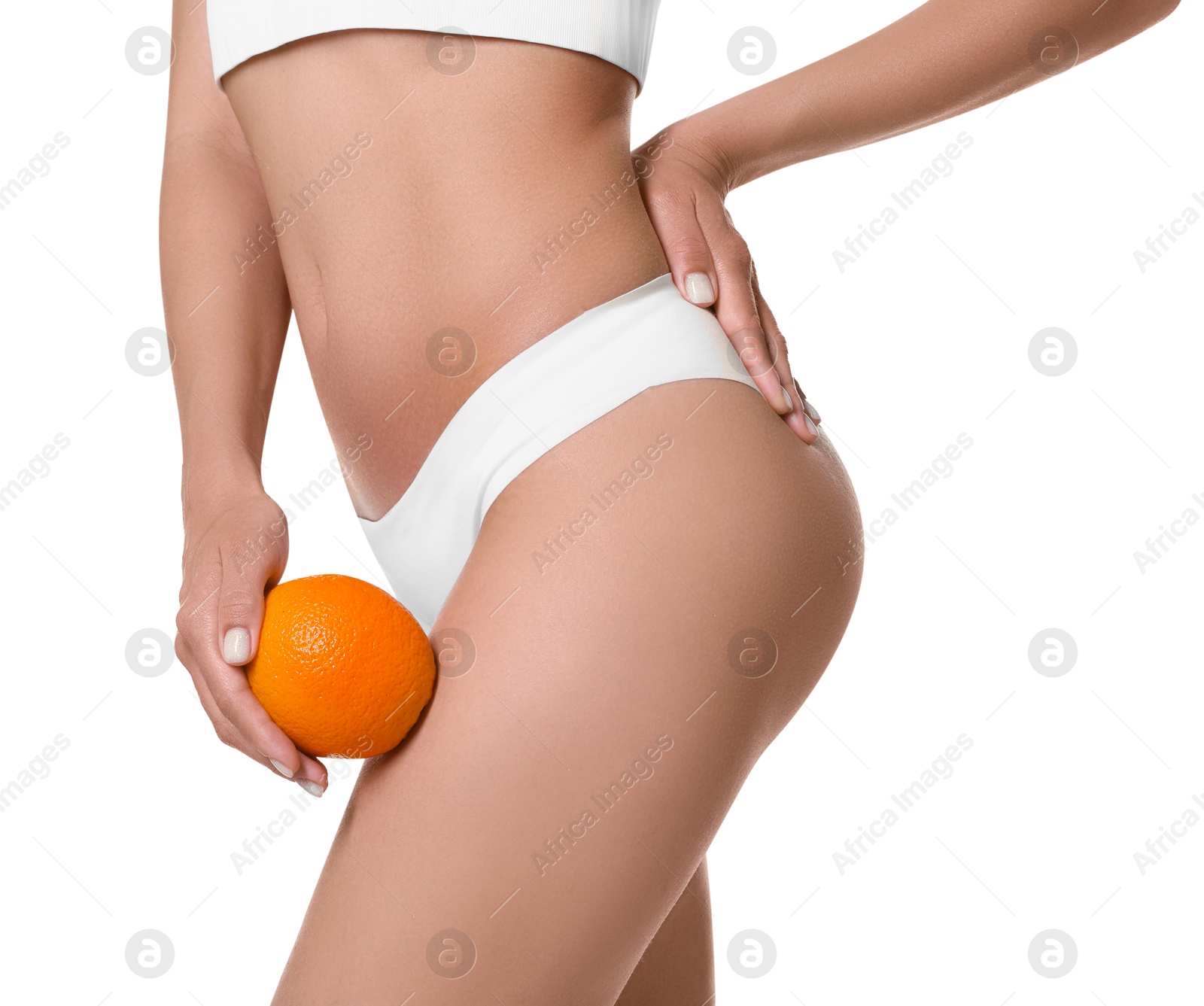 Photo of Woman in underwear with orange on white background, closeup. Cellulite problem