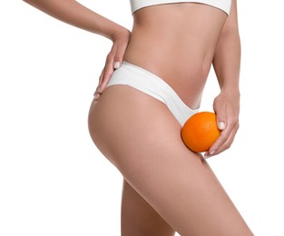 Woman in underwear with orange on white background, closeup. Cellulite problem