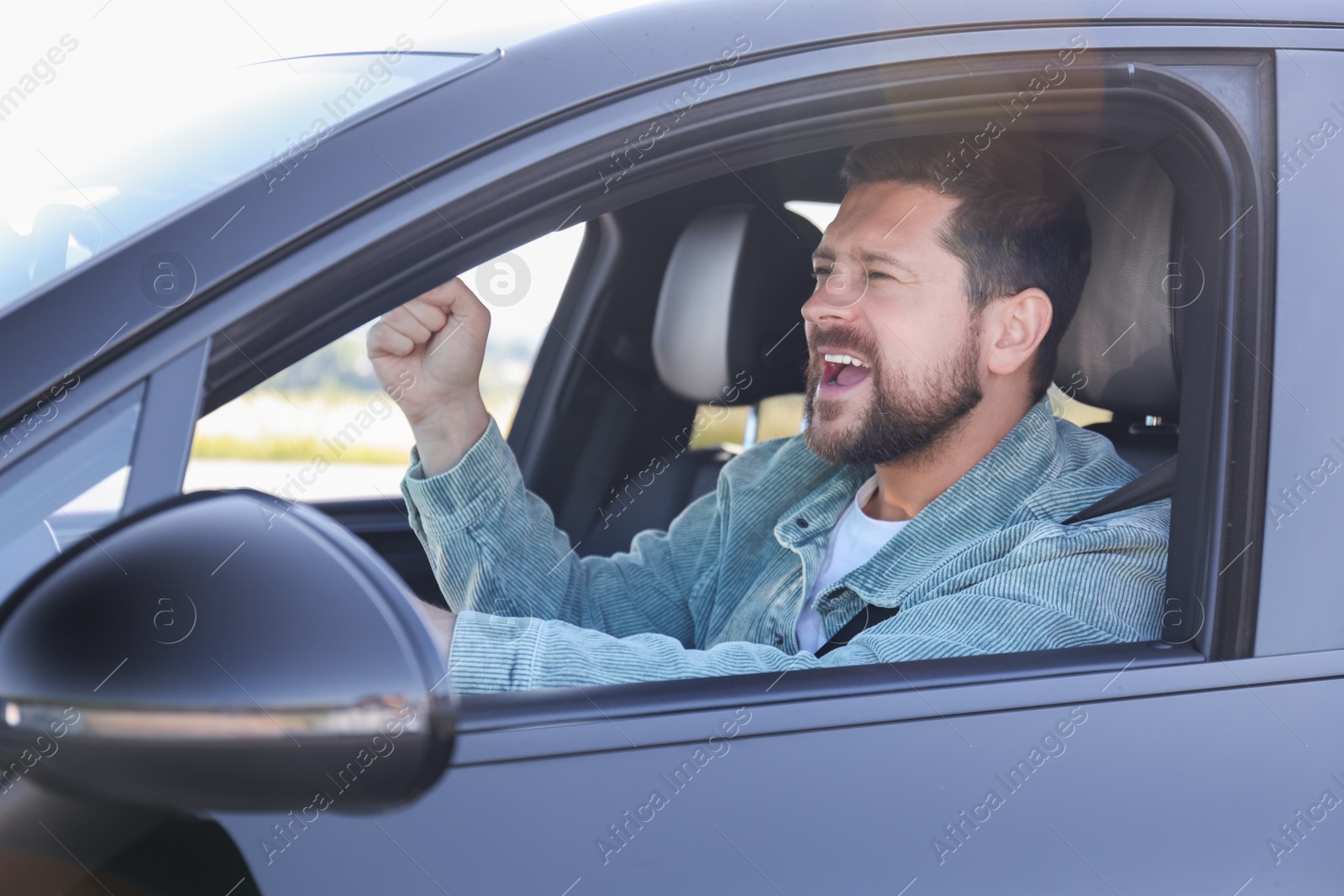 Photo of Man singing in car, view from outside