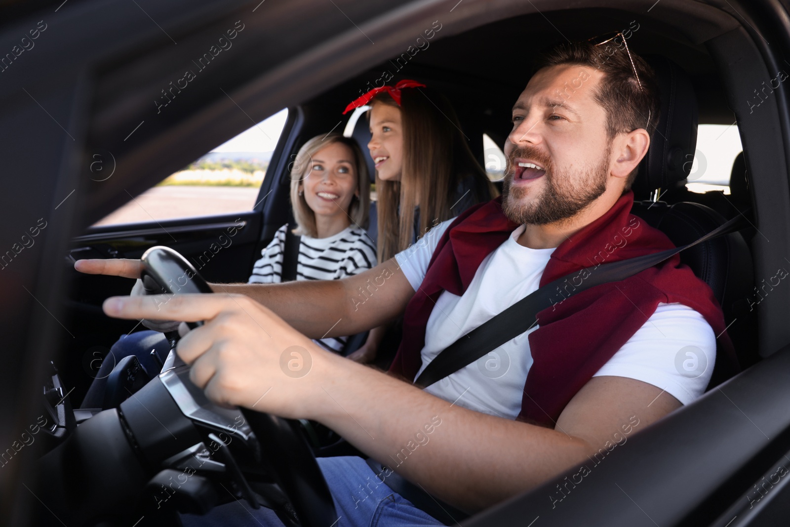 Photo of Happy family singing in car, view from outside