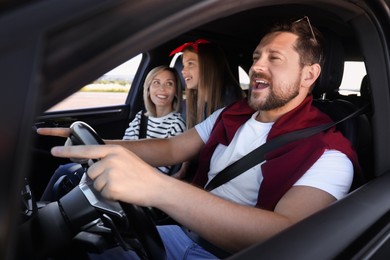 Photo of Happy family singing in car, view from outside