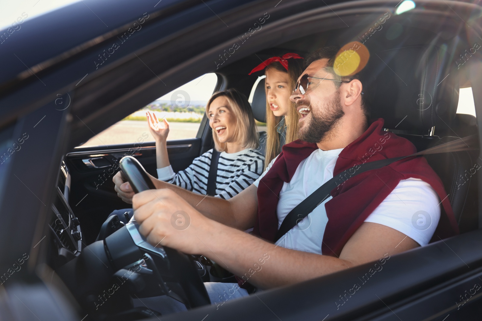 Photo of Happy family singing in car, view from outside