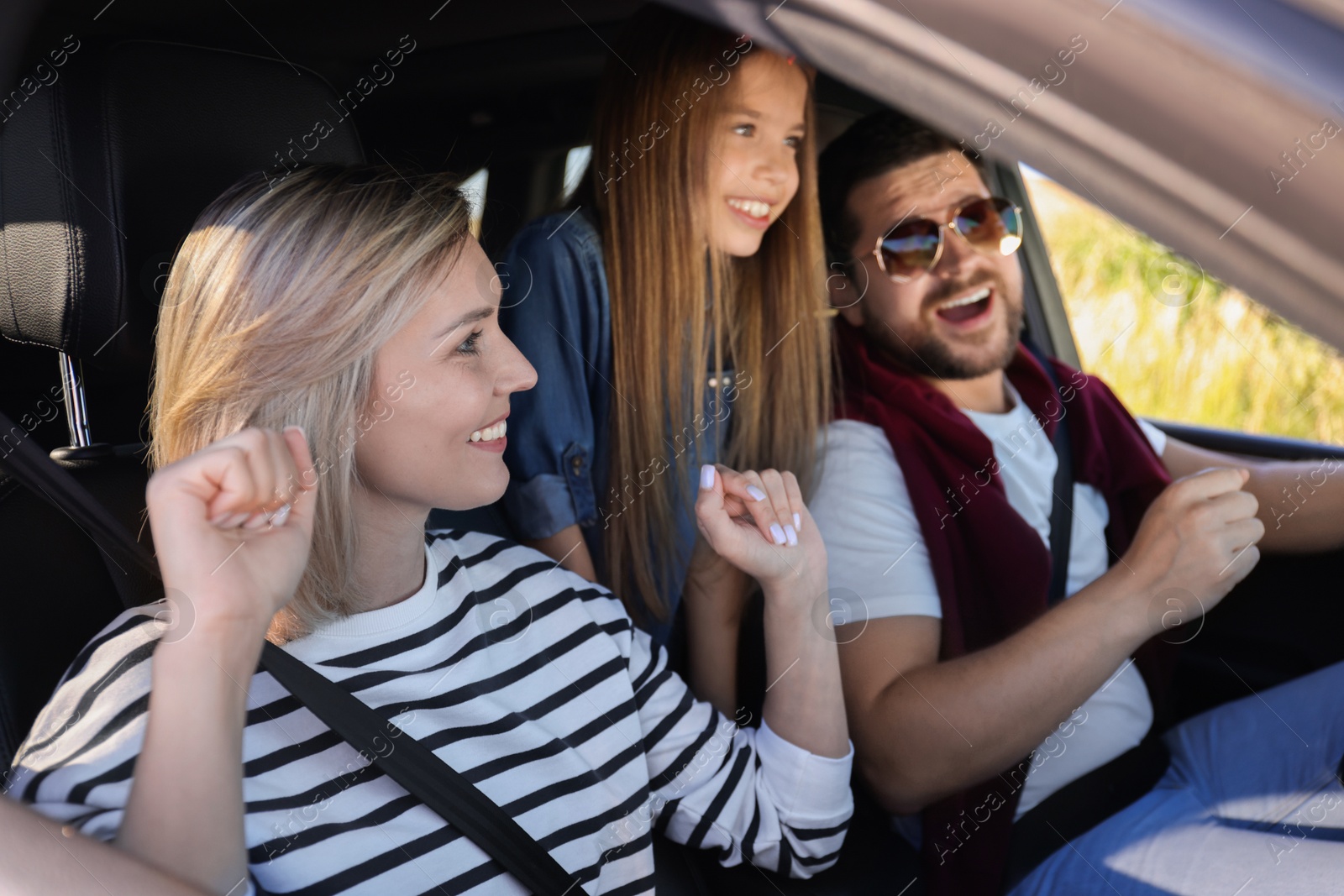 Photo of Happy family singing in car, view from outside