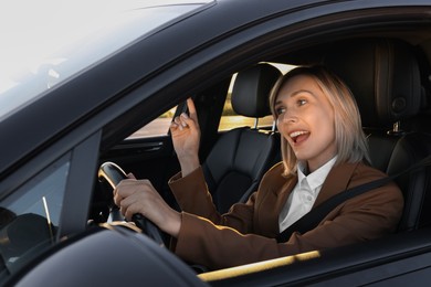 Photo of Woman singing in car, view from outside