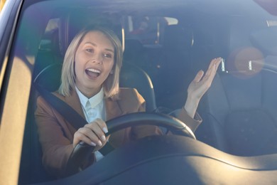 Photo of Woman singing in car, view through windshield