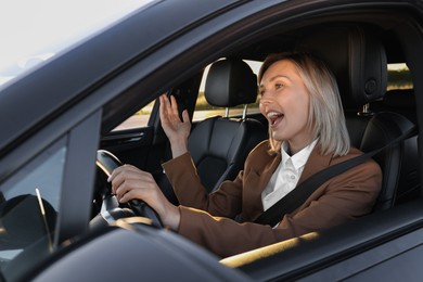 Woman singing in car, view from outside