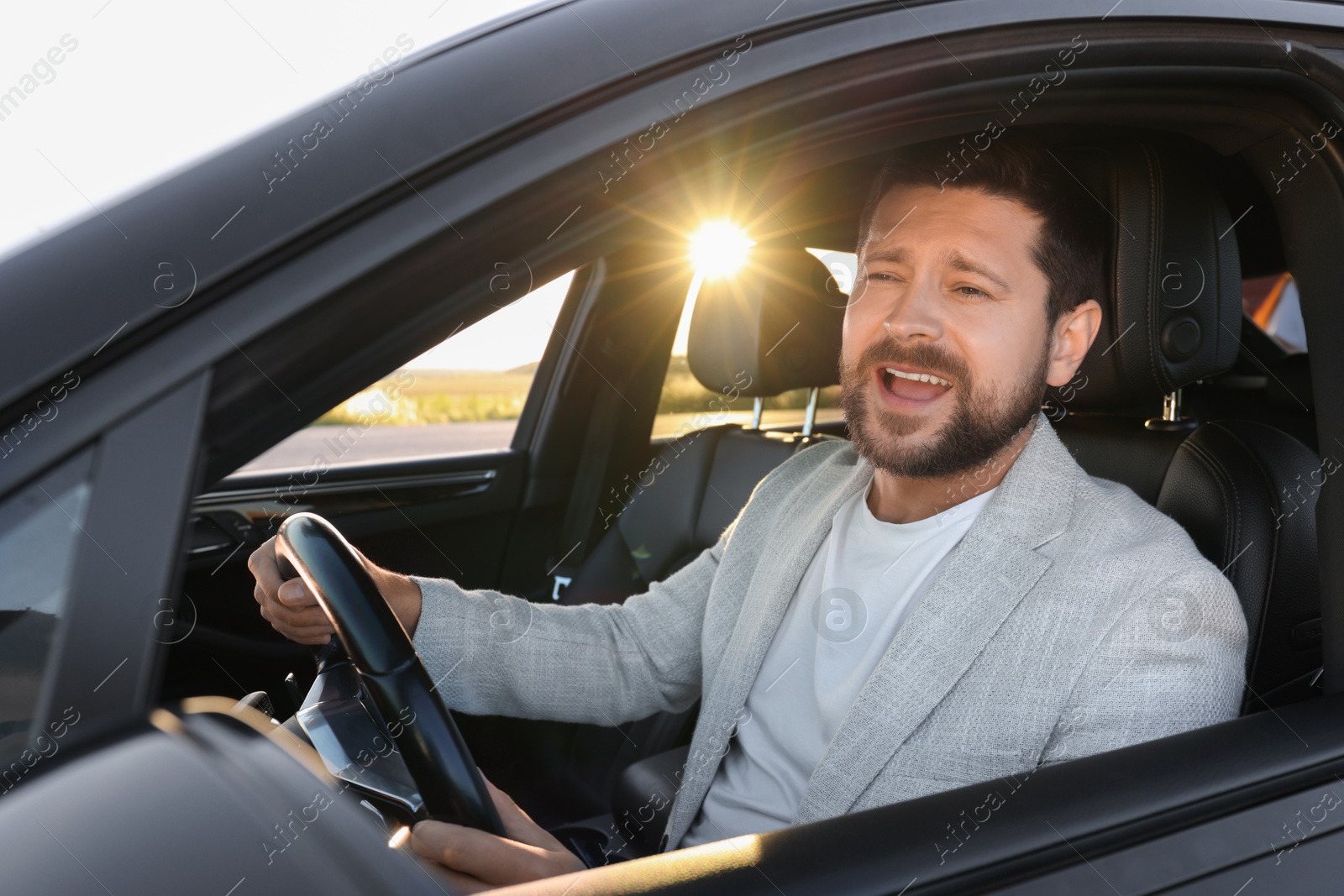 Photo of Man singing in car, view from outside