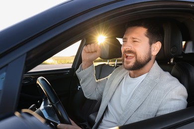 Photo of Man singing in car, view from outside