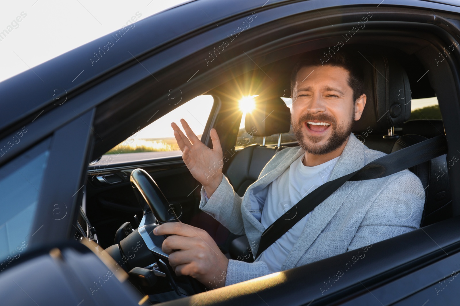 Photo of Man singing in car, view from outside