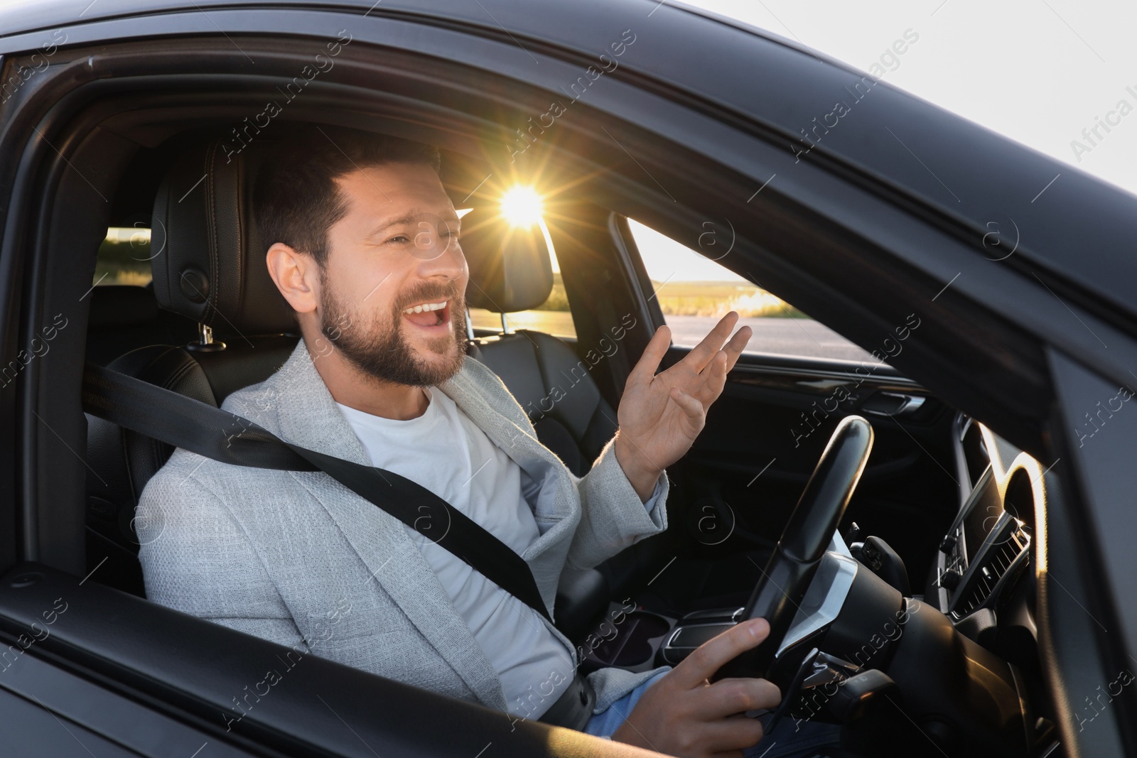 Photo of Man singing in car, view from outside