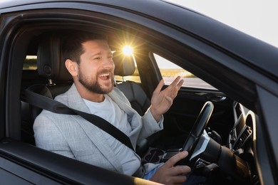 Man singing in car, view from outside