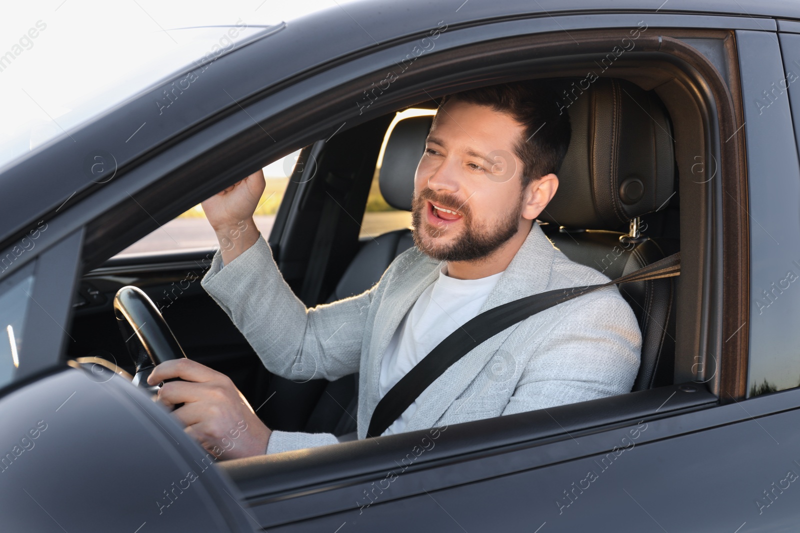 Photo of Man singing in car, view from outside