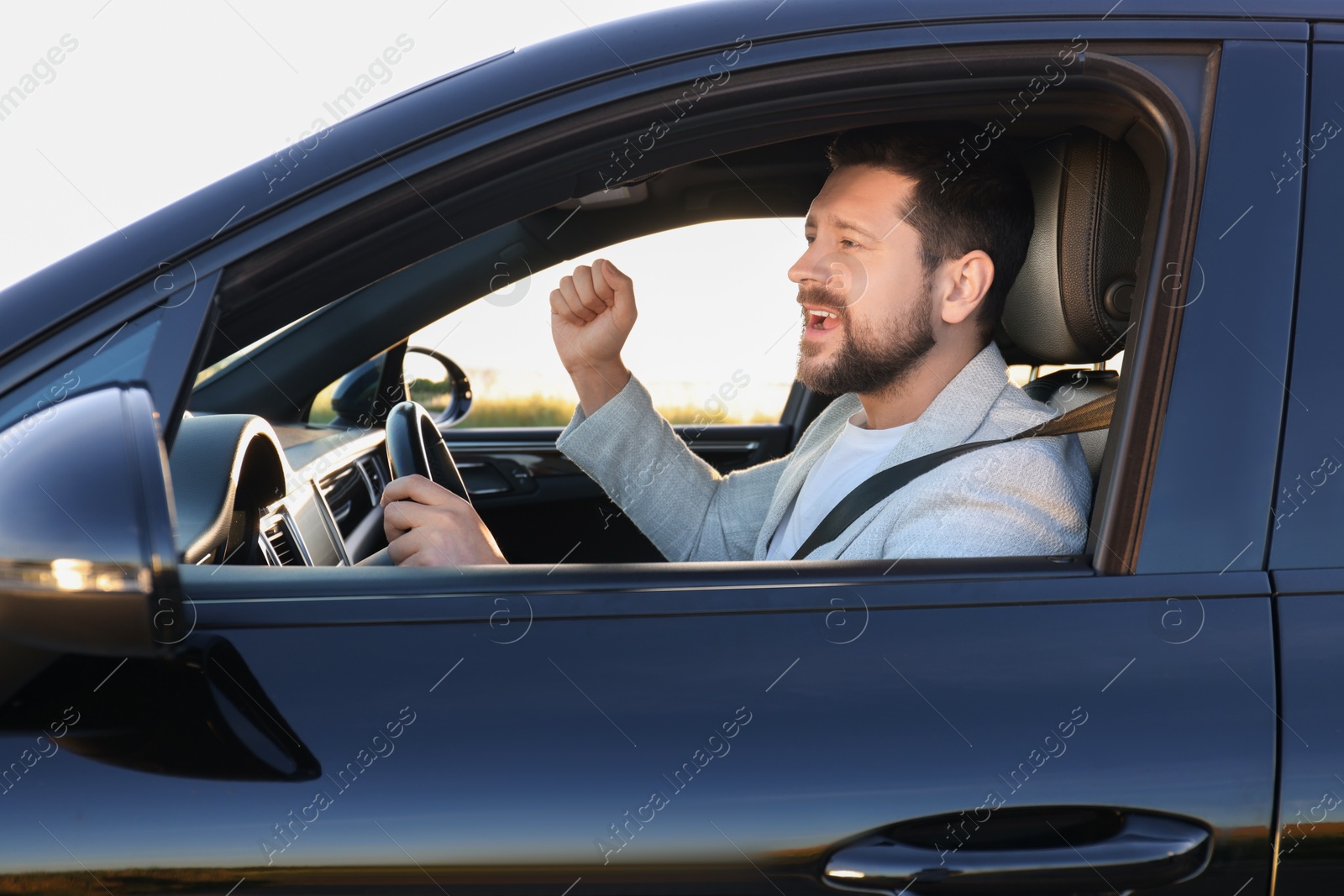 Photo of Man singing in car, view from outside