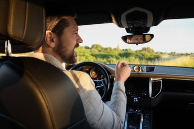 Photo of Man singing in car, view from inside