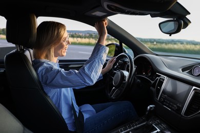 Woman singing in car, view from outside