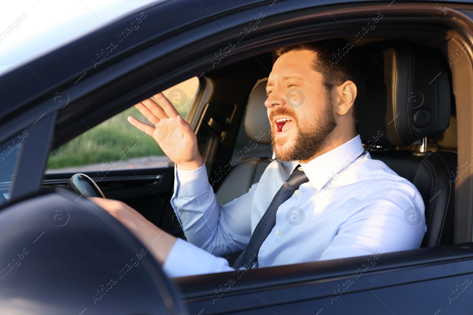 Photo of Man singing in car, view from outside