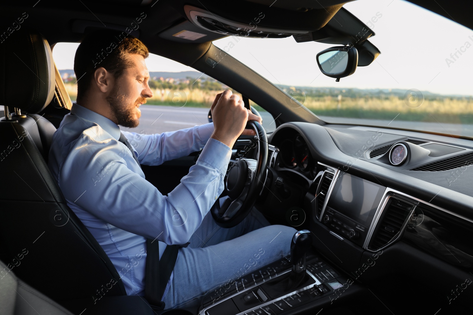 Photo of Man singing in car, view from inside