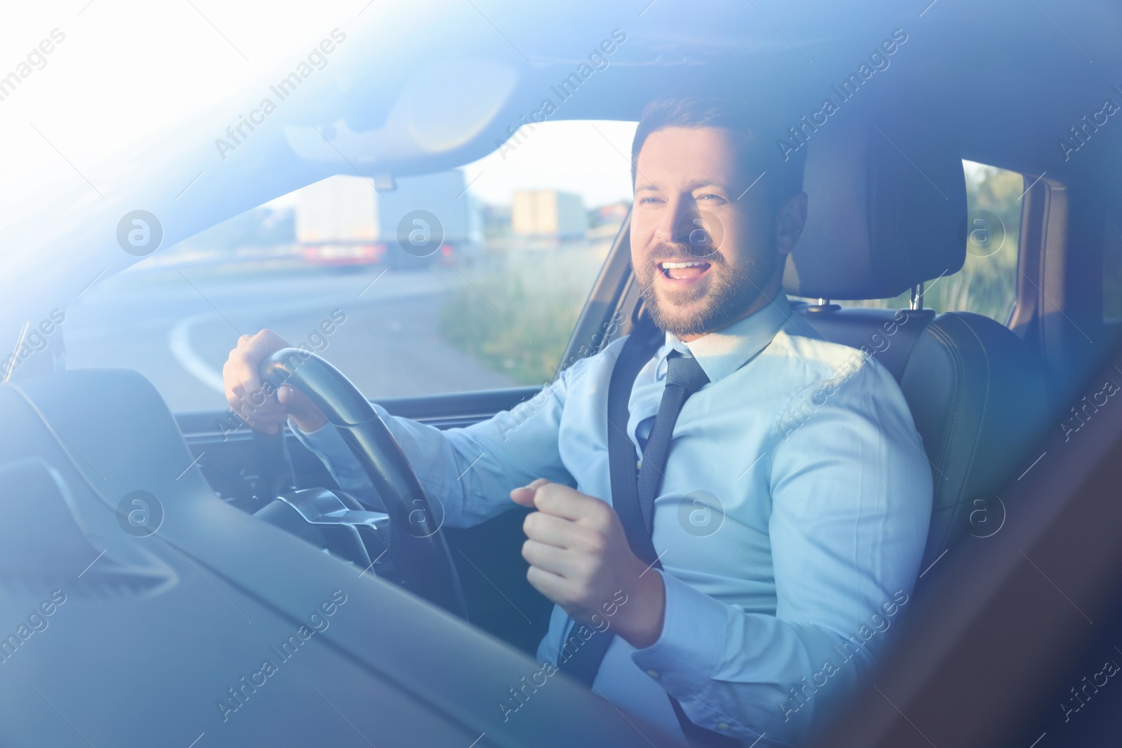 Photo of Man singing in car, view through windshield